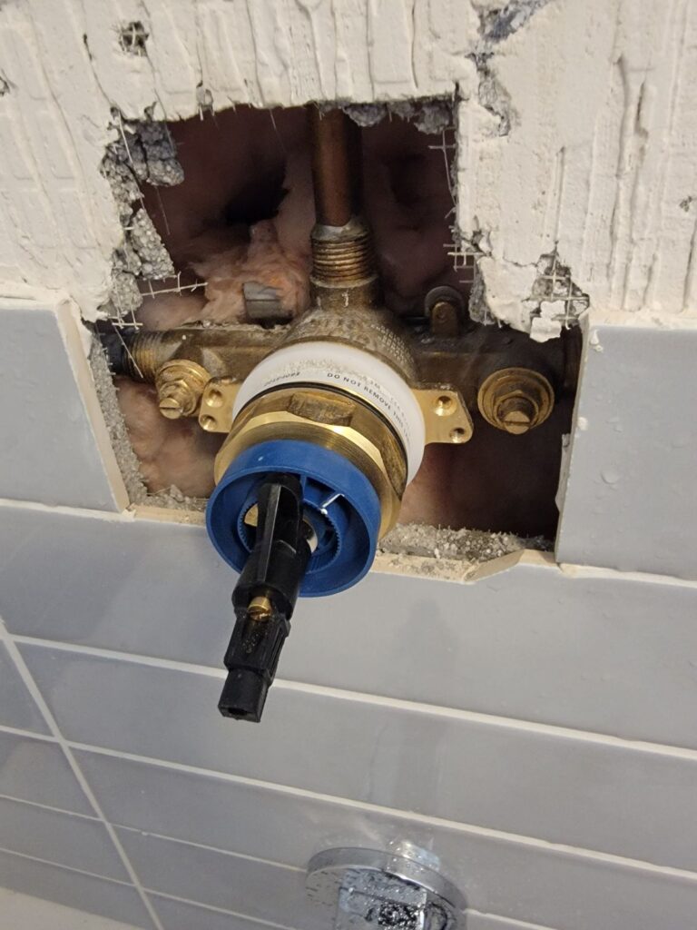 Shower valve cartridge replacement in a tiled bathroom